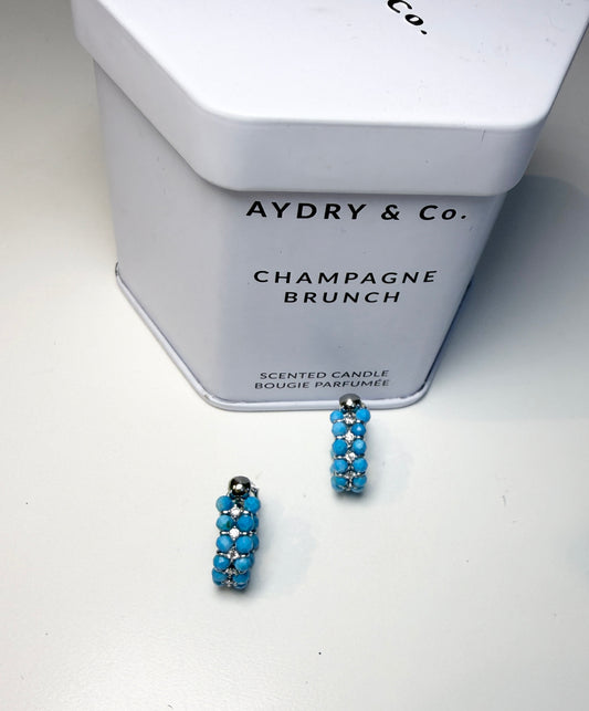 Wearing two pearl, turquoise and black spinel earrings