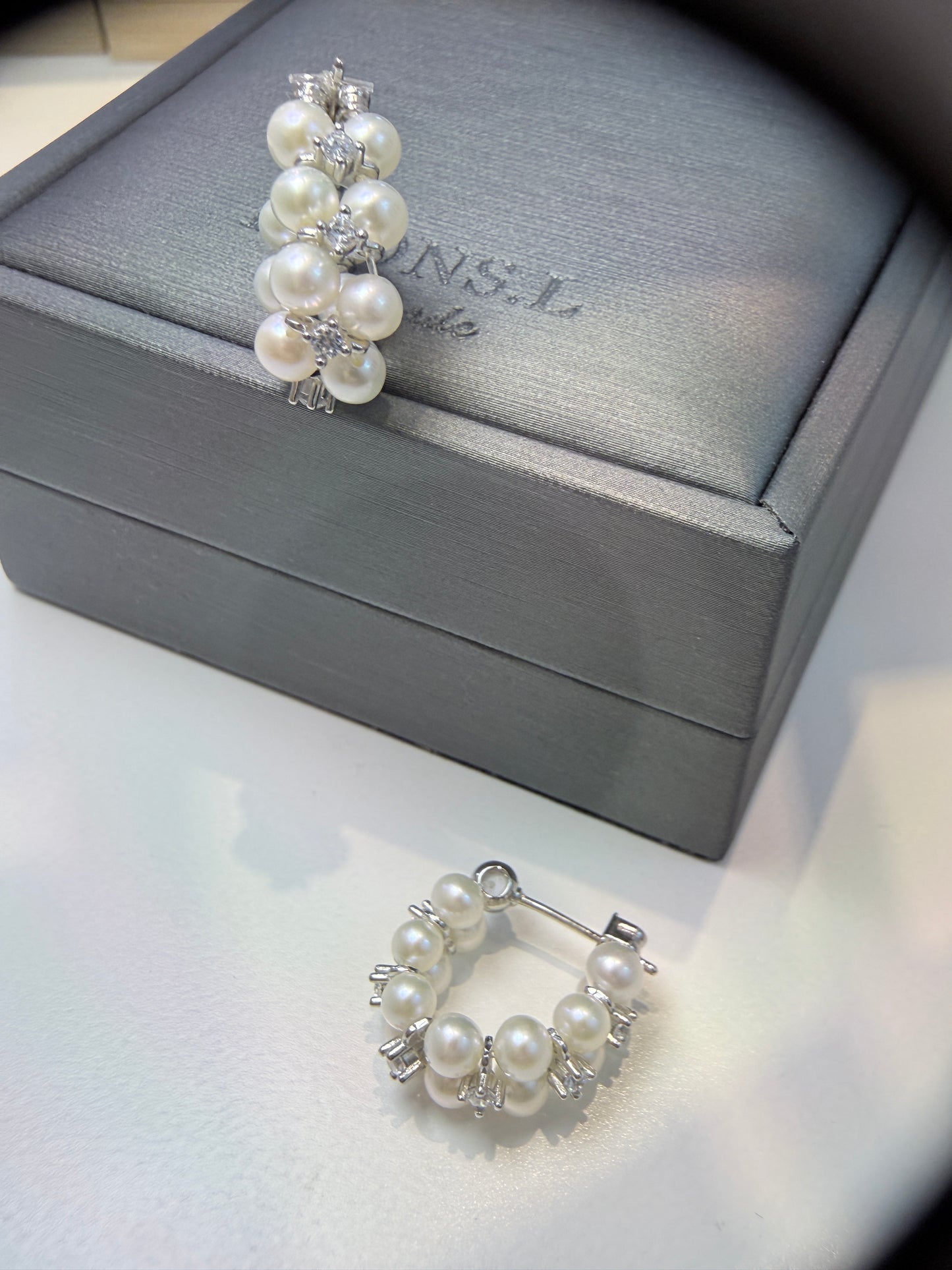 Wearing two pearl, turquoise and black spinel earrings