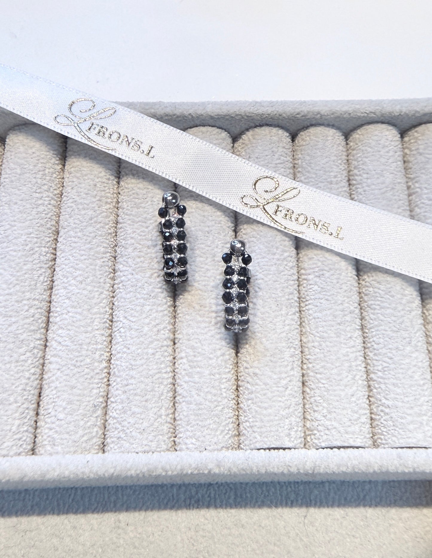 Wearing two pearl, turquoise and black spinel earrings