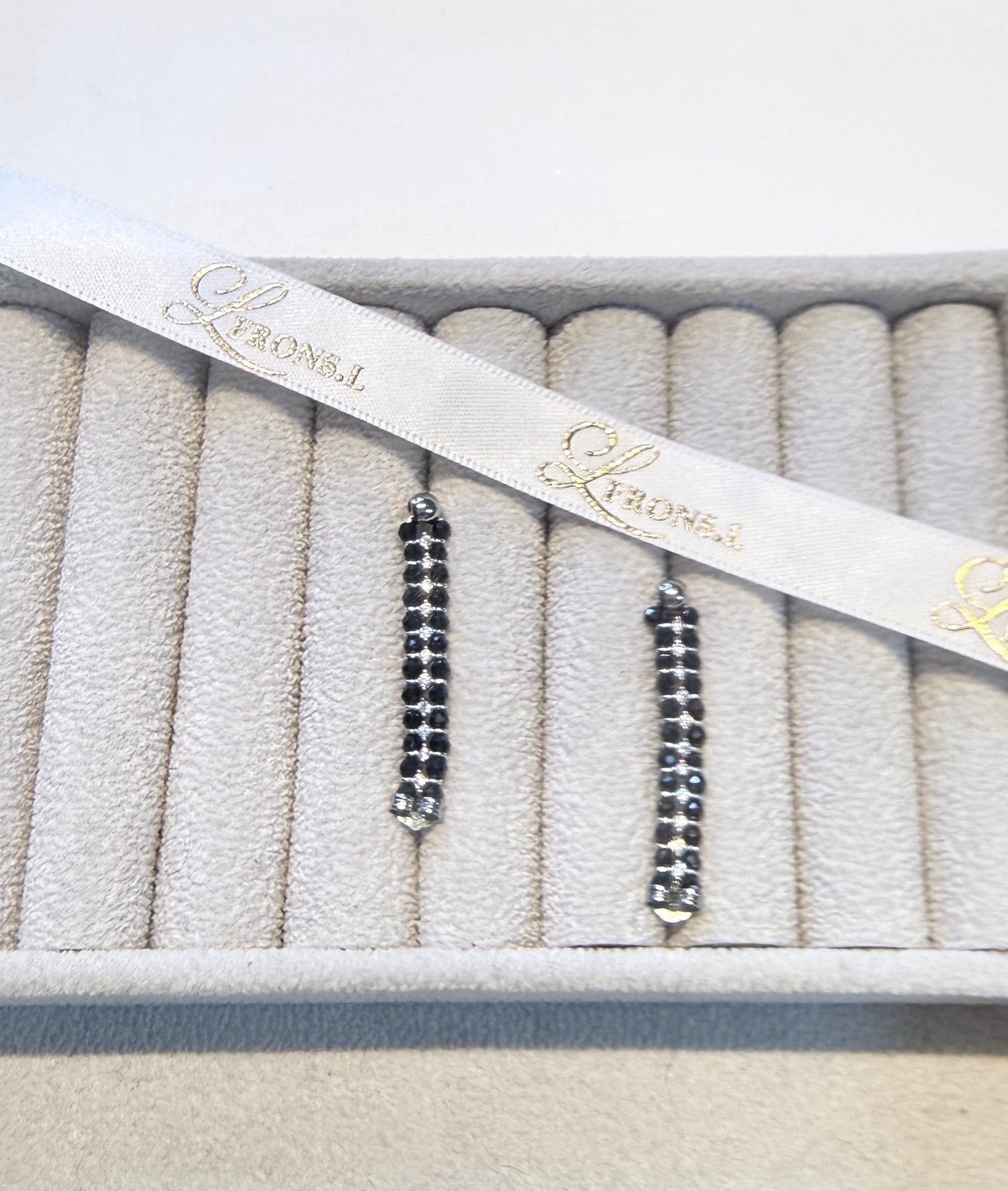 Wearing two pearl, turquoise and black spinel earrings