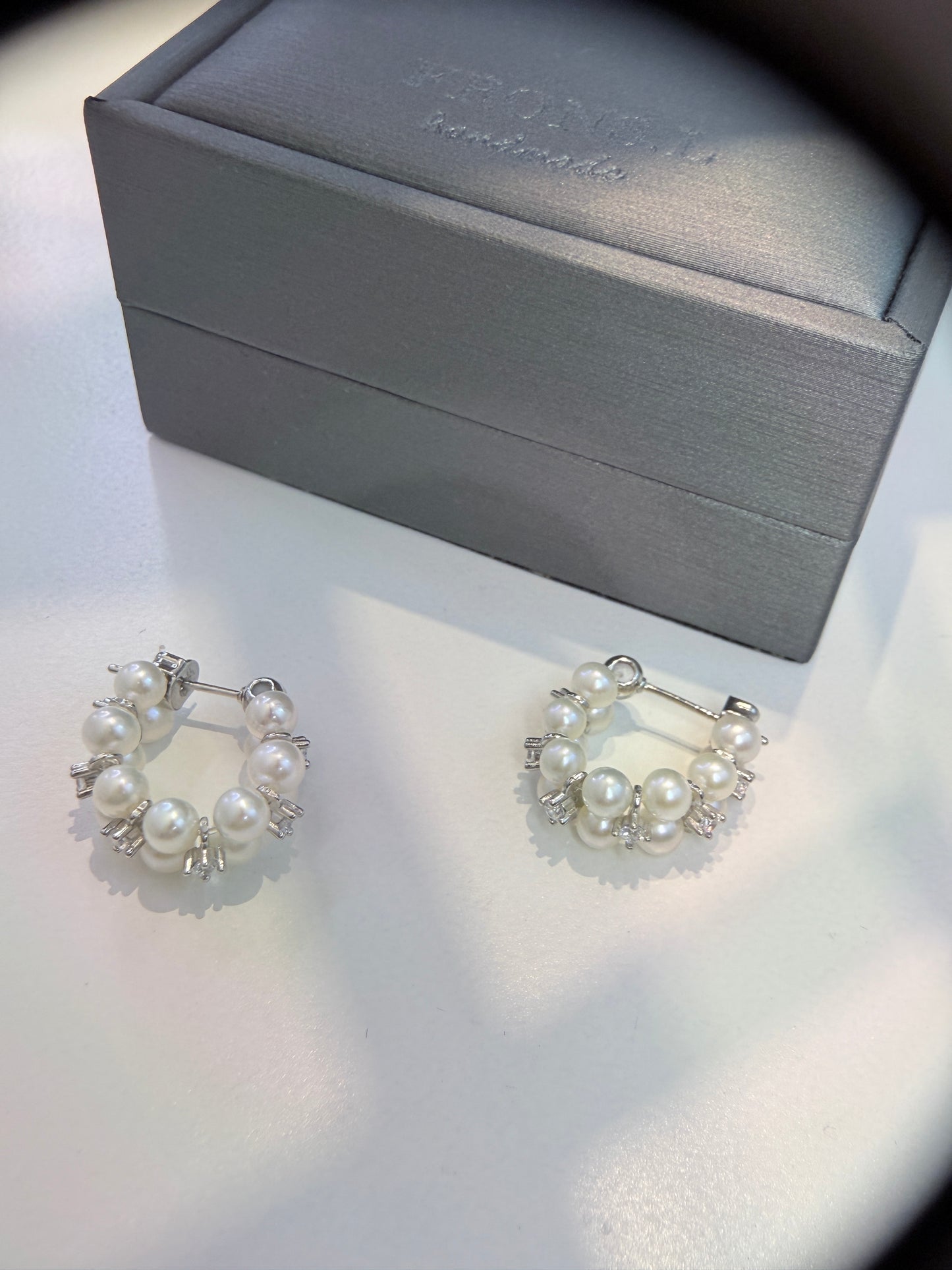 Wearing two pearl, turquoise and black spinel earrings